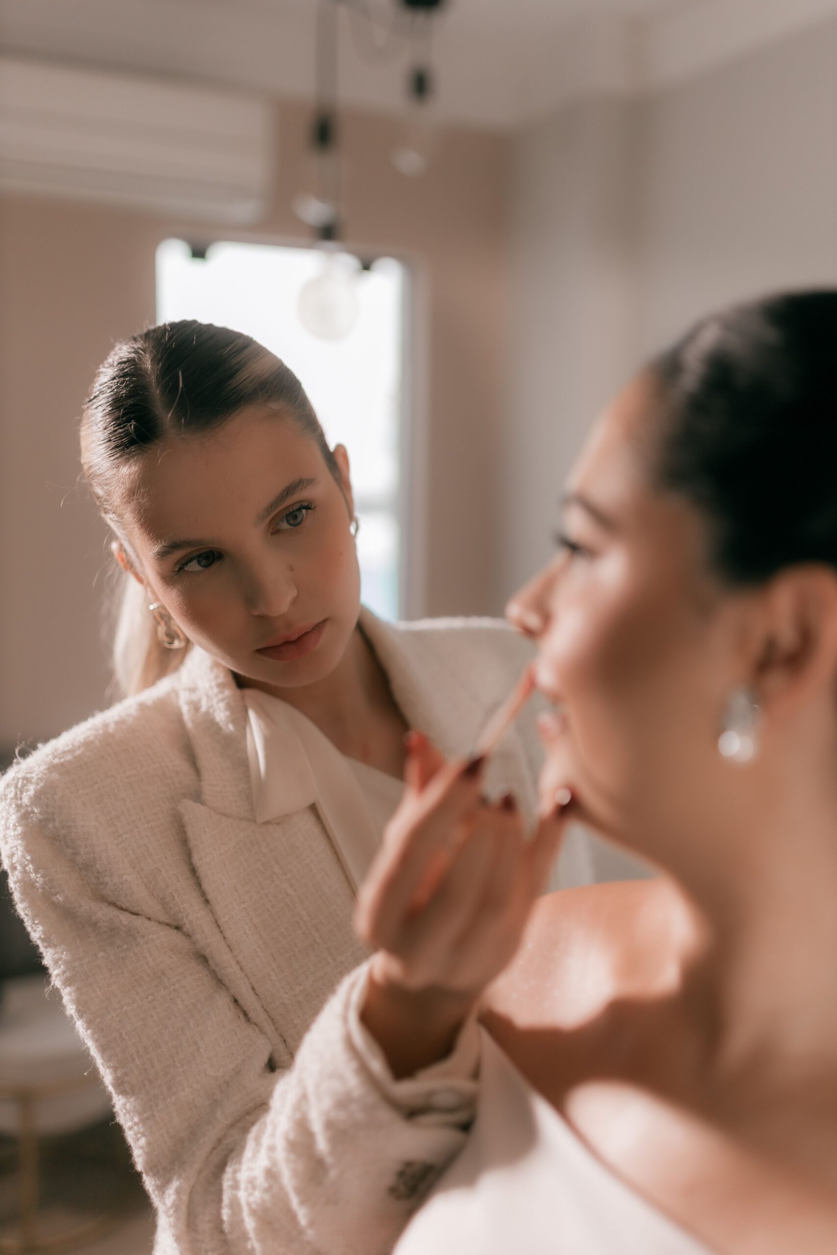 Wedding business owner applying makeup to a bride.