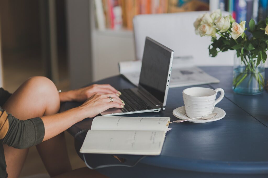 Woman sitting at table doing maintenance on her website.