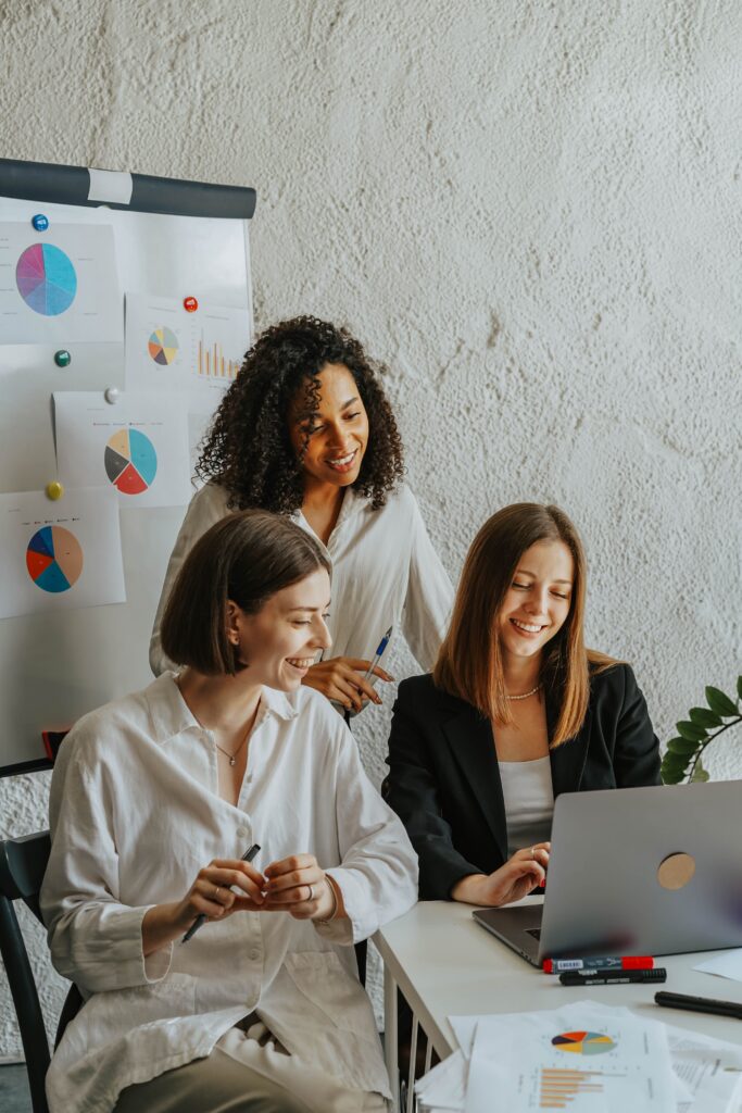 A group of women talking about how they can help wedding professionals avoid making these website design mistakes.